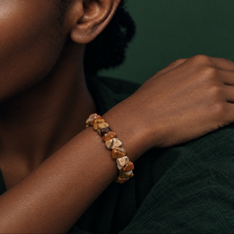 Picture jasper chip stretch bracelet worn on the wrist, model in a dark green sweater
