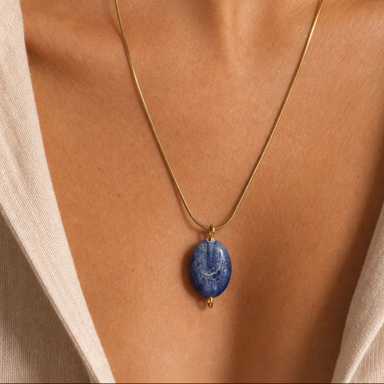 Necklace with a blue kyanite pendant on a person's neck