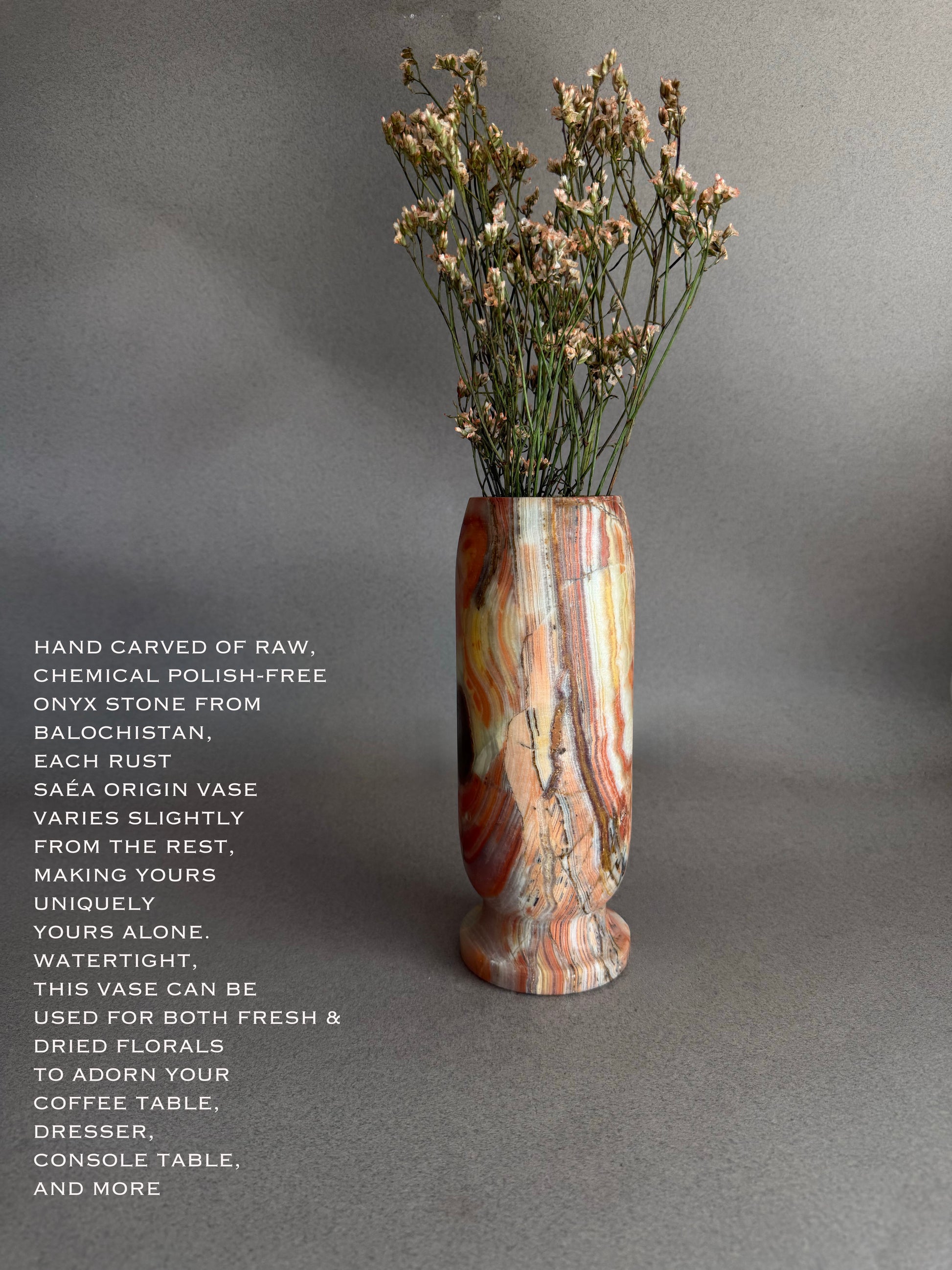 Decorative red green amber rust orange onyx natural stone vase with dried flowers on a gray background