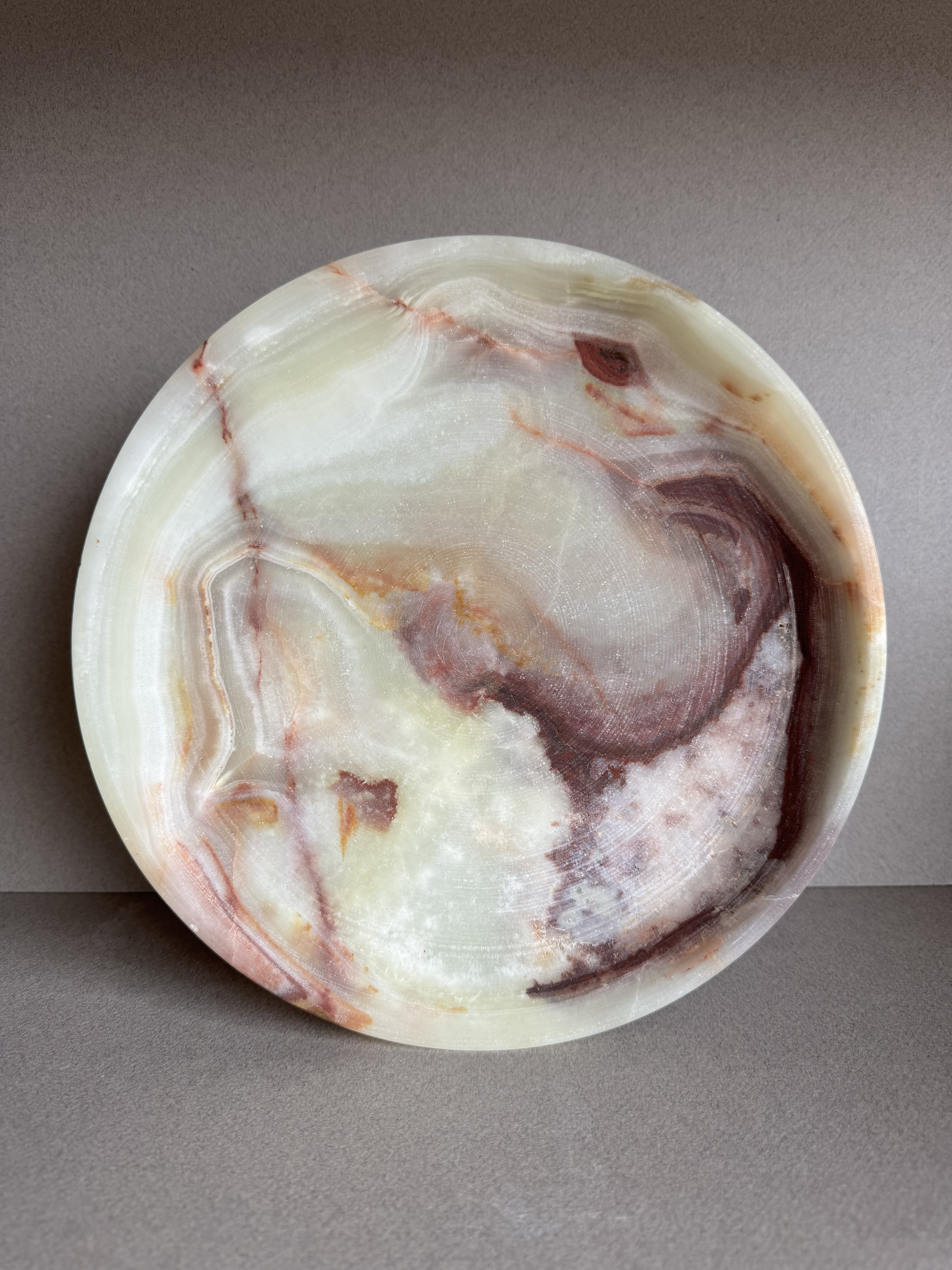 Close-up of natural onyx veining in warm cream, rust, and amber tones, highlighting the stone’s texture and detail