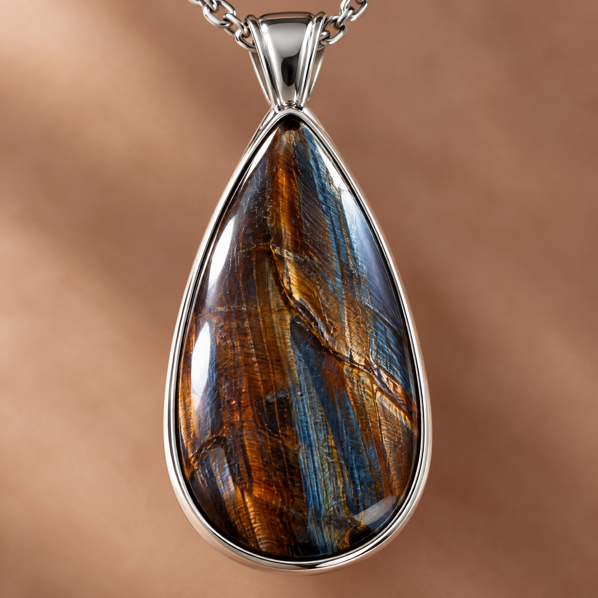 Macro close-up of the navy, rust and copper pietersite teardrop pendant in a silver bezel.