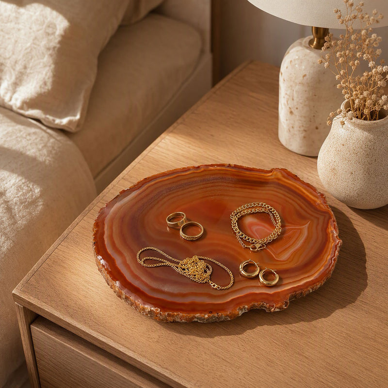 Rust and amber agate slice on a bedside table, holding jewelry as a ring dish