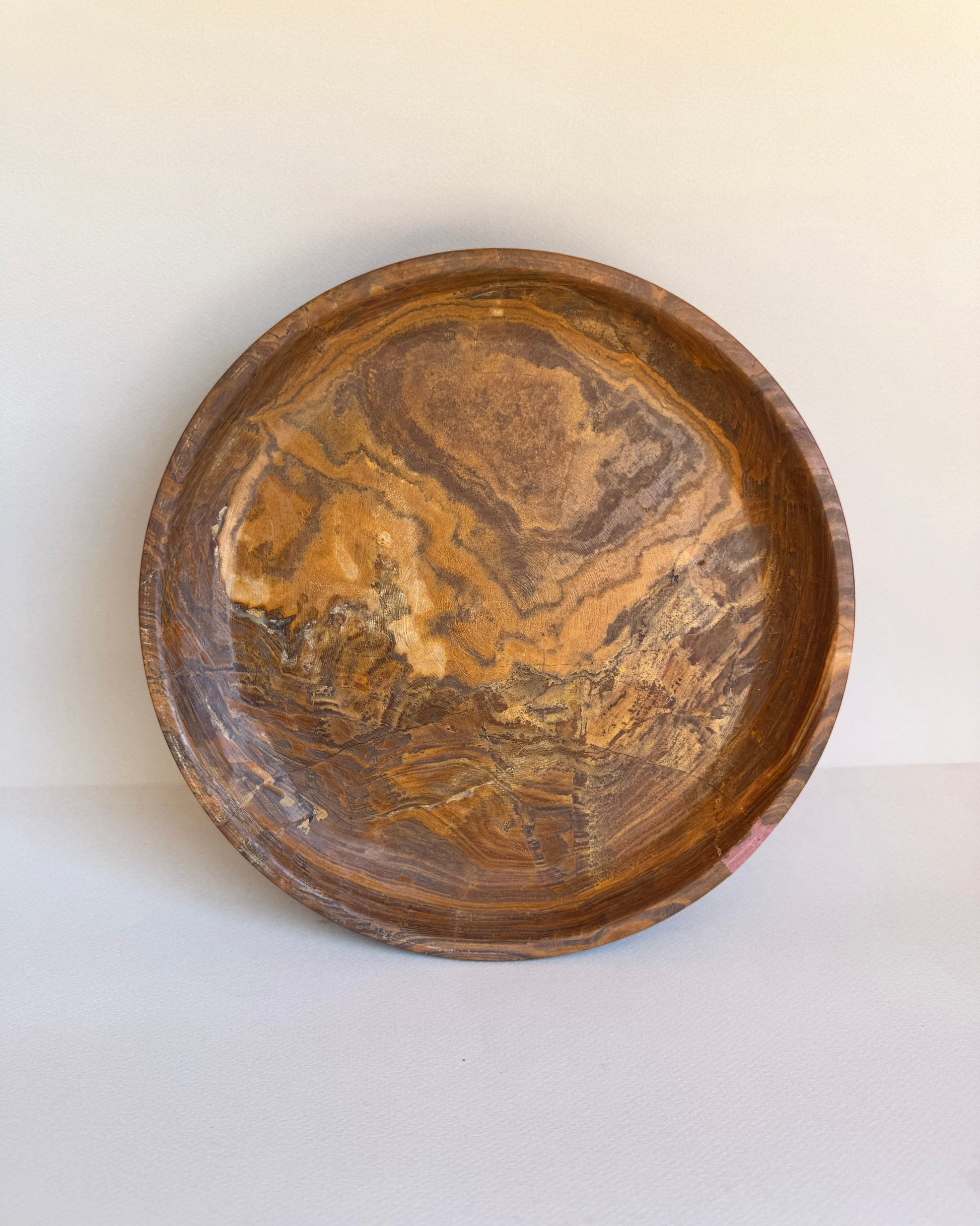 Wooden bowl with marbled pattern on a white background