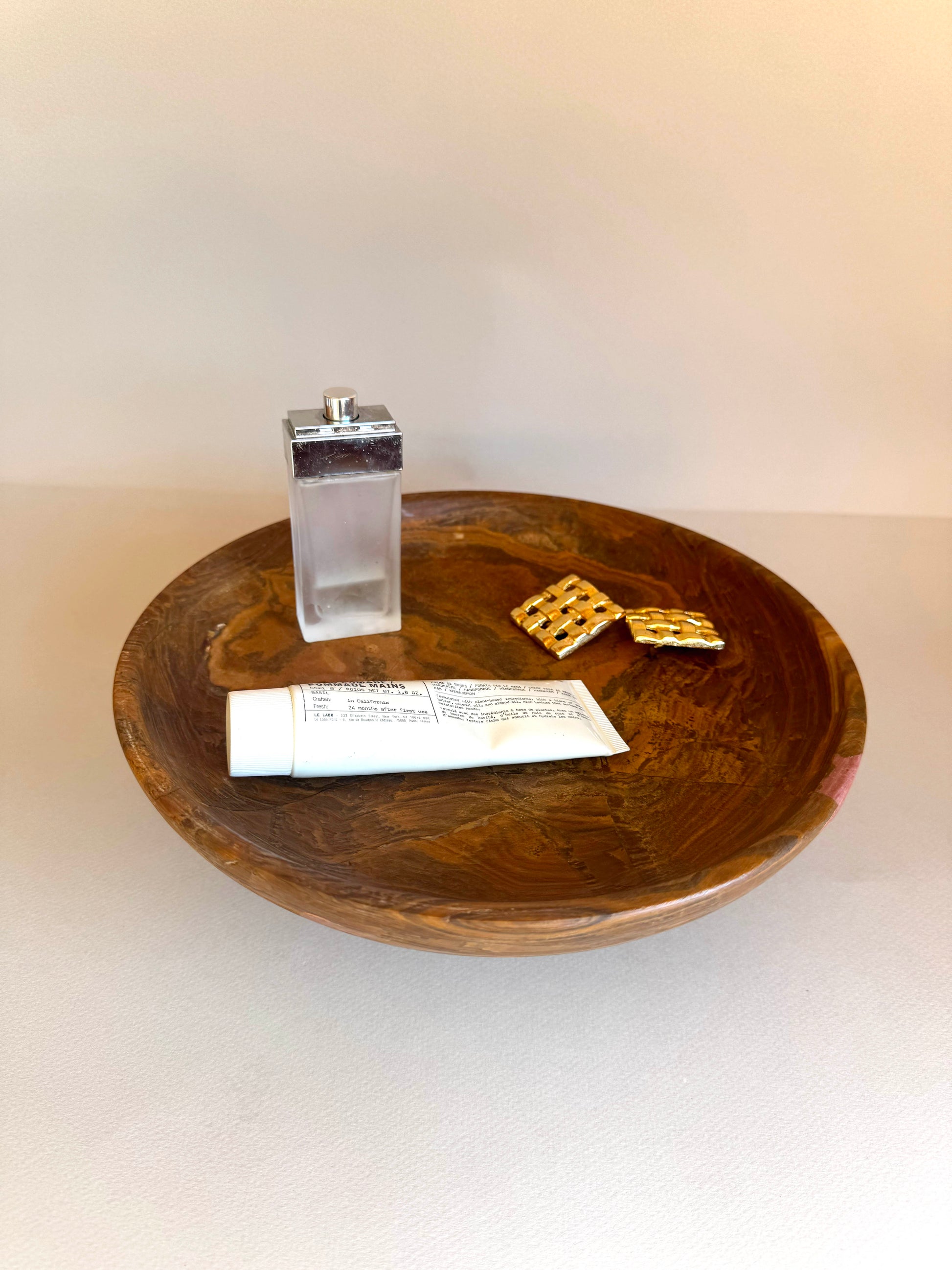 Wooden bowl with a salt shaker, paper, and crackers on a white background