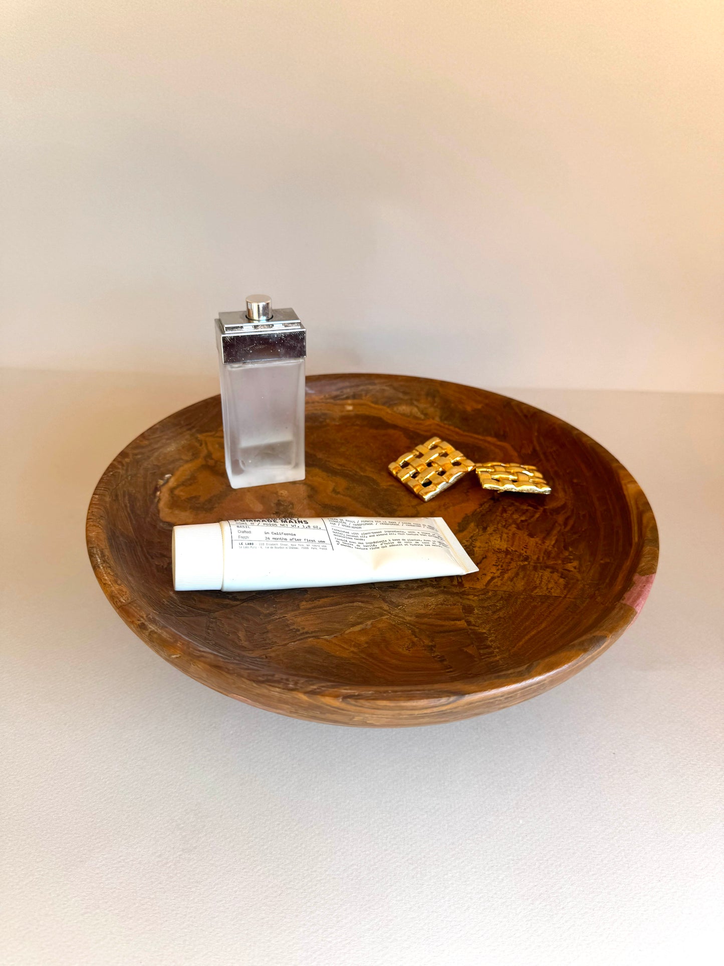 Wooden bowl with a salt shaker, paper, and crackers on a white background