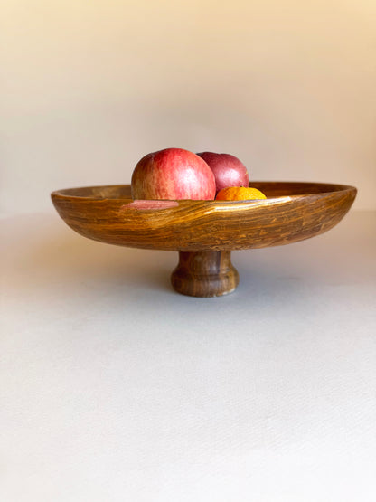 Wooden bowl with apples on a white surface