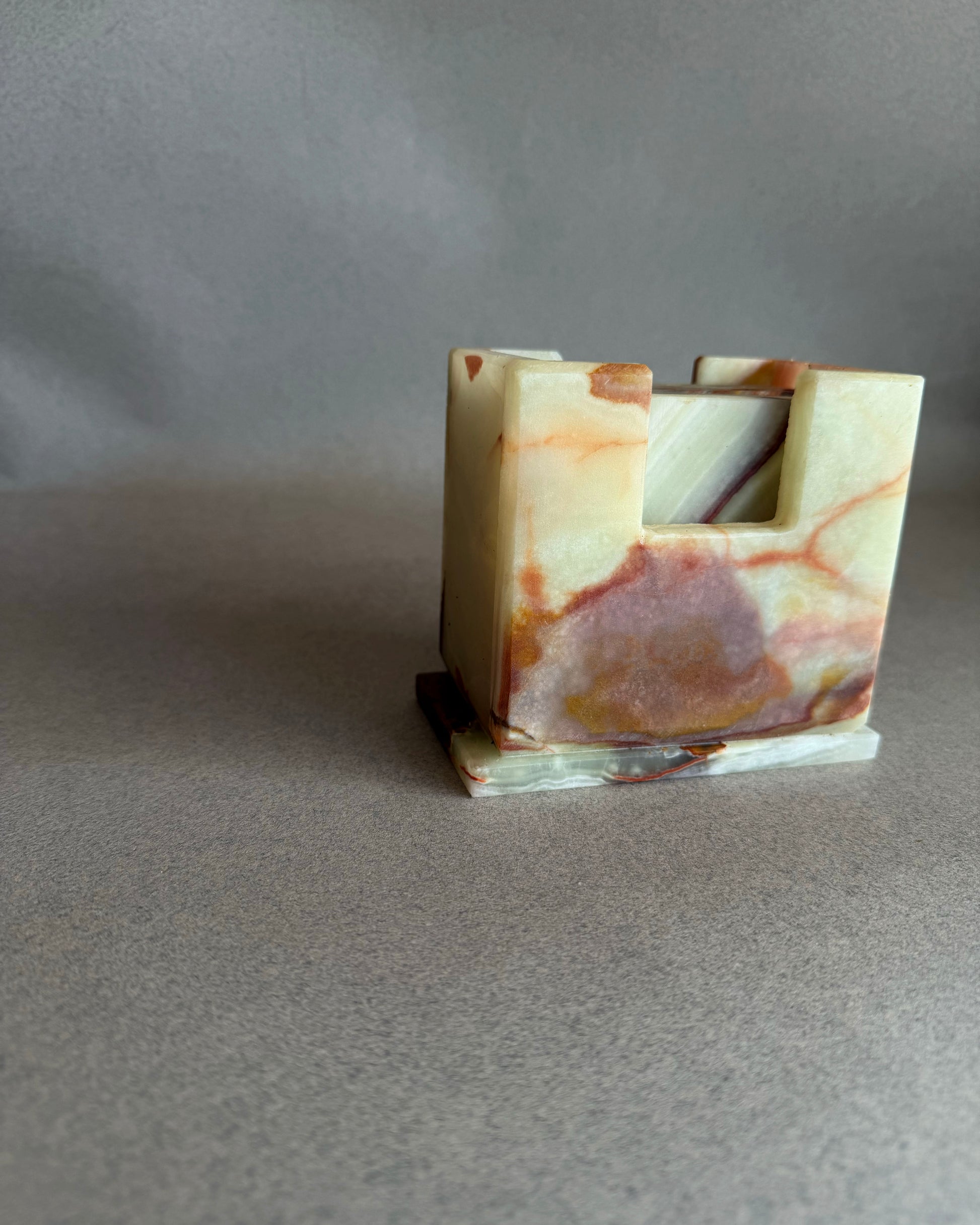 Square onyx coaster in pale cream stone with soft rust veining and subtle translucency shown close up
