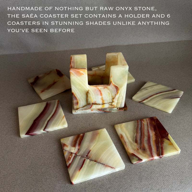 Set of 6 natural onyx stone coasters with matching carved holder, showing translucent ivory, honey, and rust mineral banding on neutral gray backdrop
