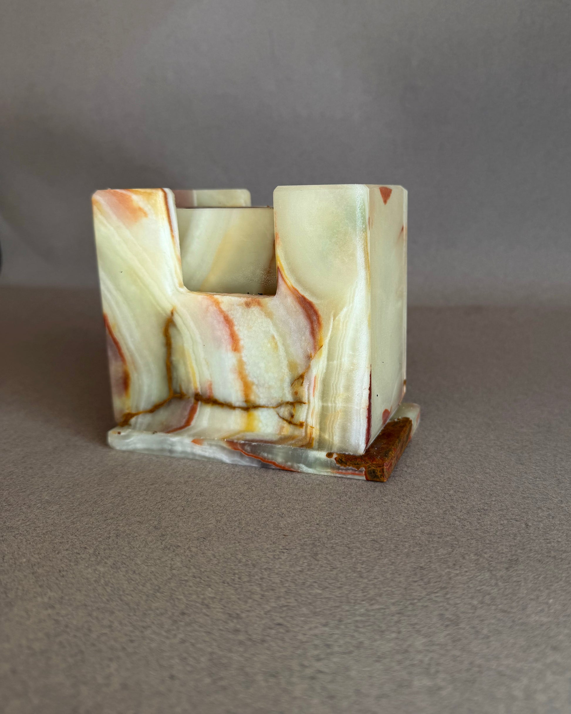 Raw onyx coaster holder carved from natural stone featuring cream ivory tones with warm amber and rust movement
