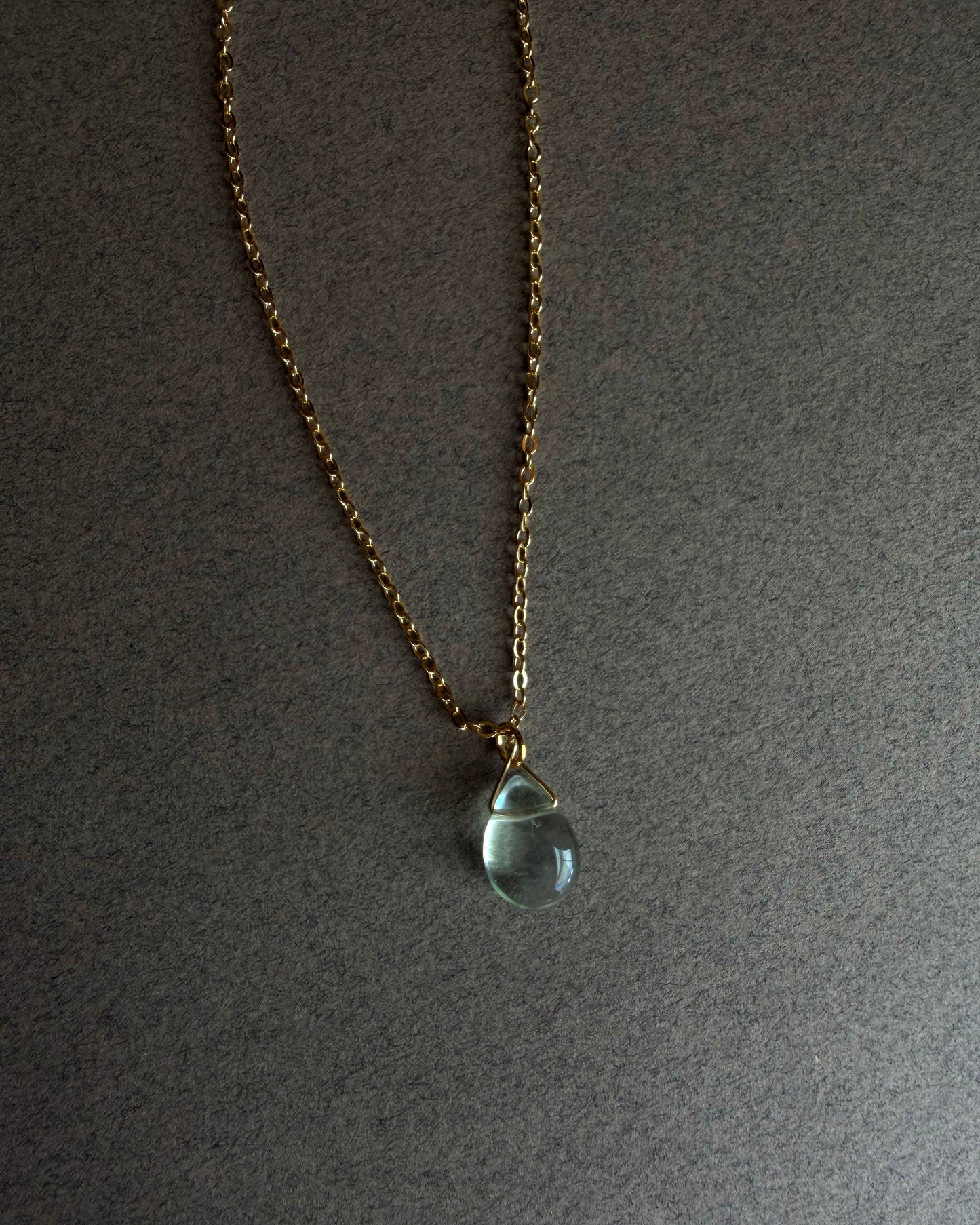Necklace with a teardrop-shaped blue fluorite pendant on a gray background