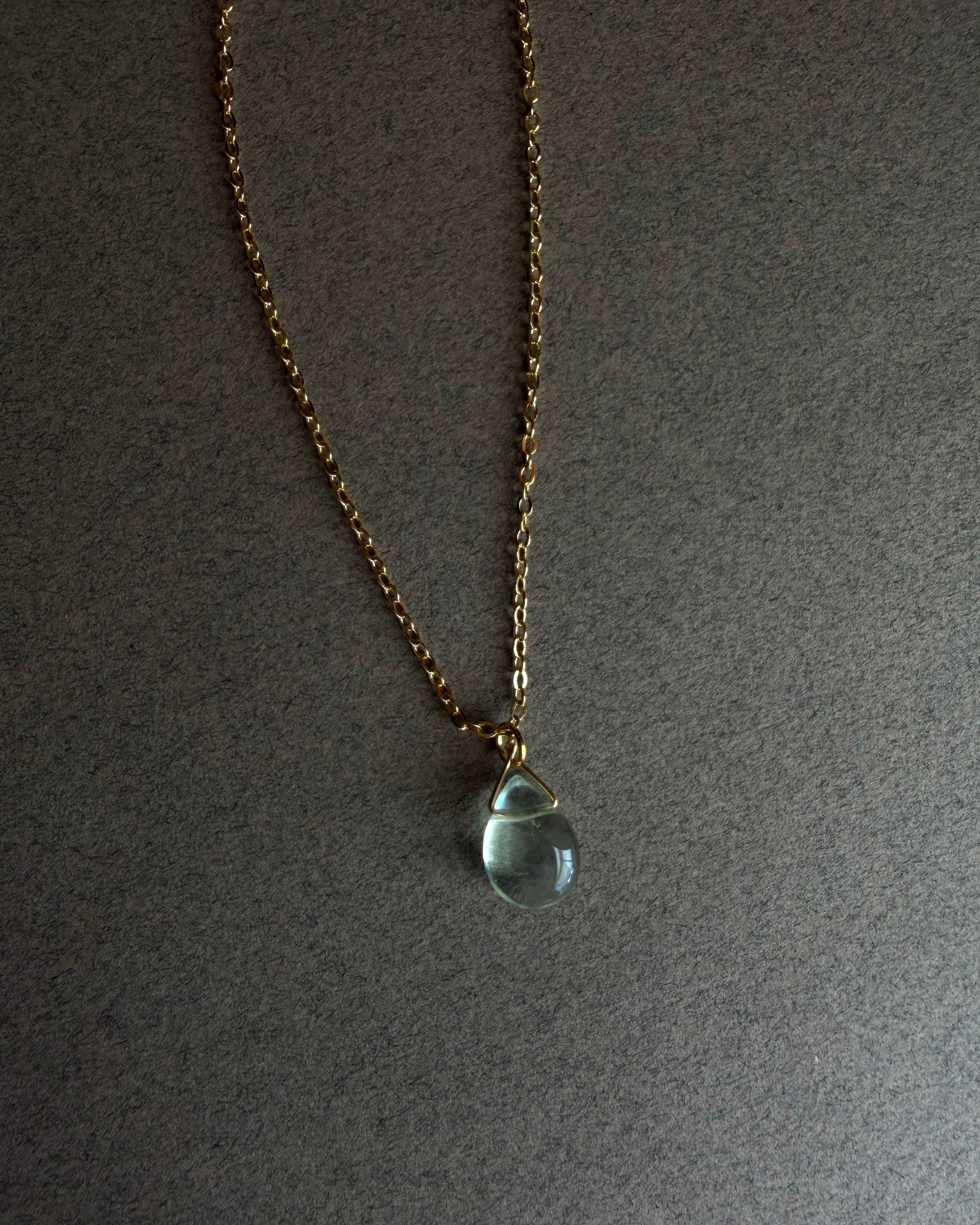 Necklace with a teardrop-shaped blue fluorite pendant on a gray background