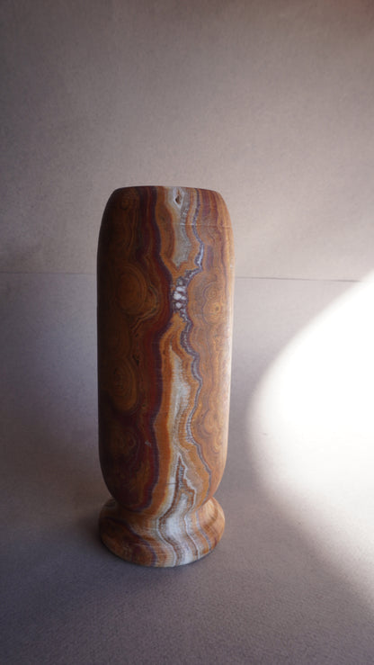 Close-up of brown onyx vase base showing natural stone veining and handcrafted texture
