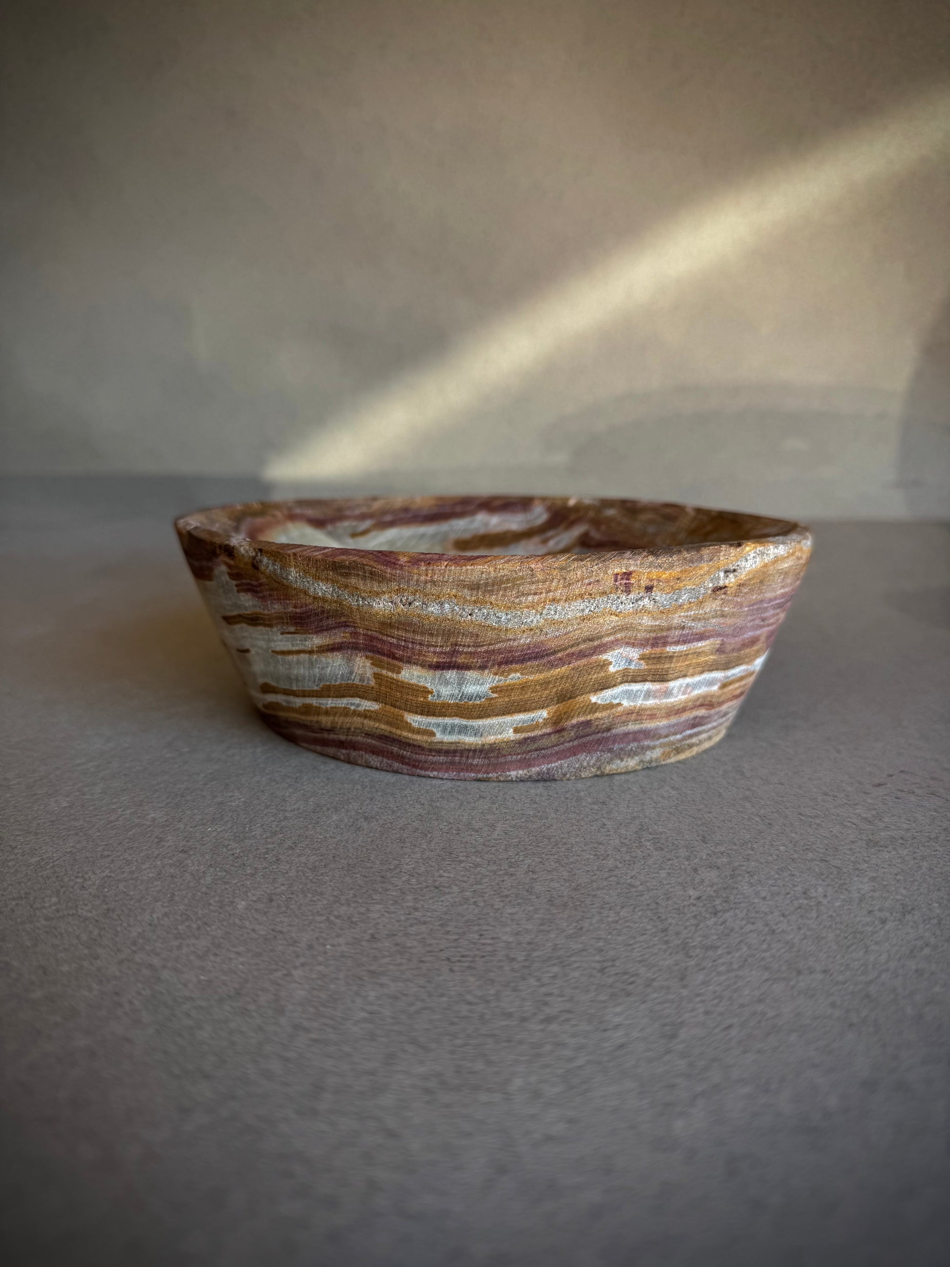 Hand-carved onyx bowl with rustic terracotta and blush tones, small decorative accent