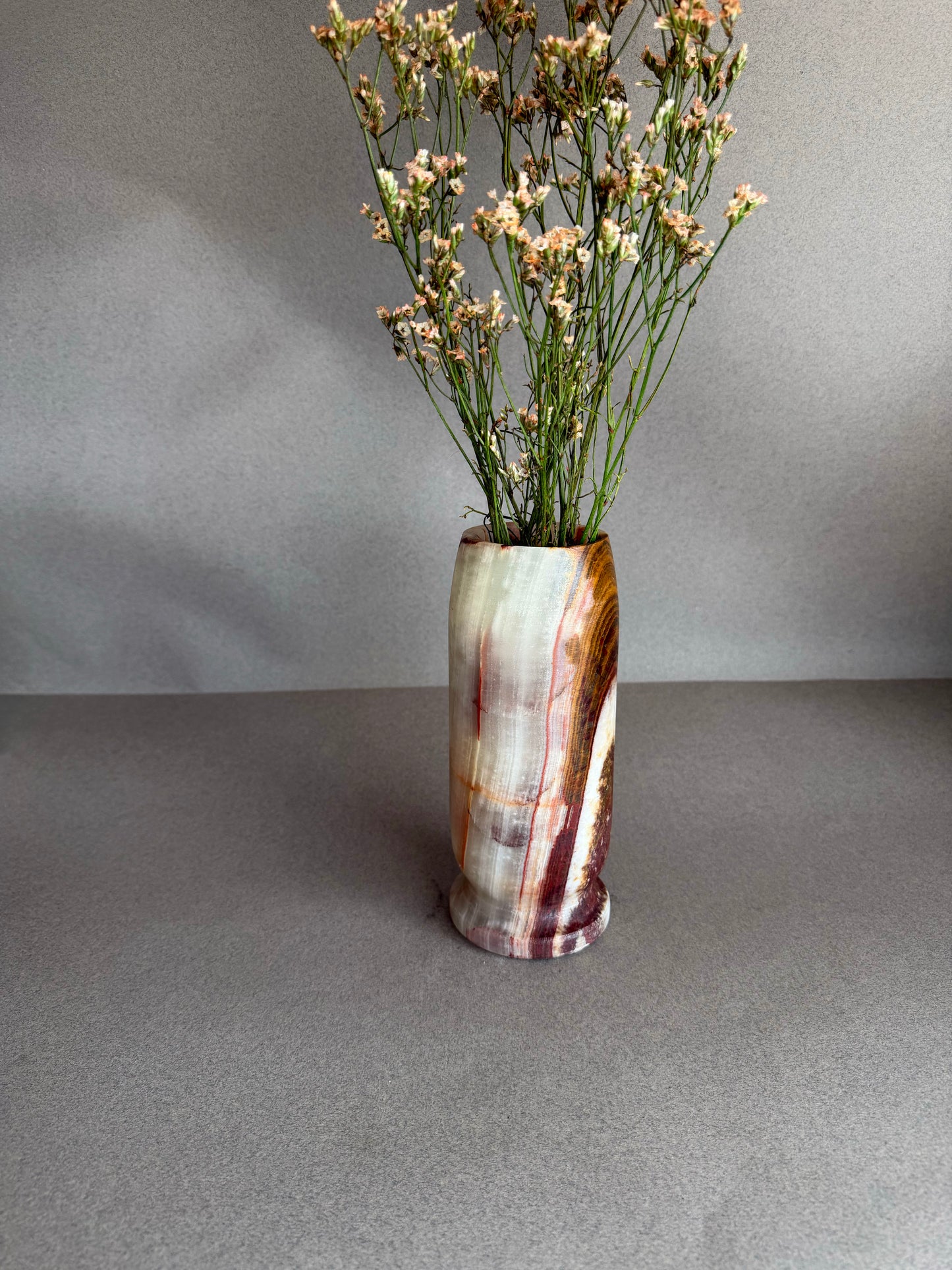 Vase with dried flowers on a gray surface and background