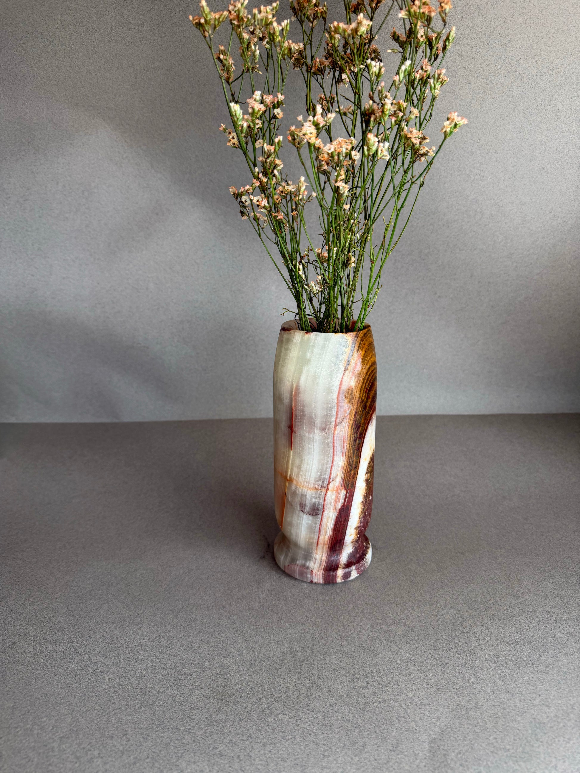 Vase with dried flowers on a gray surface and background