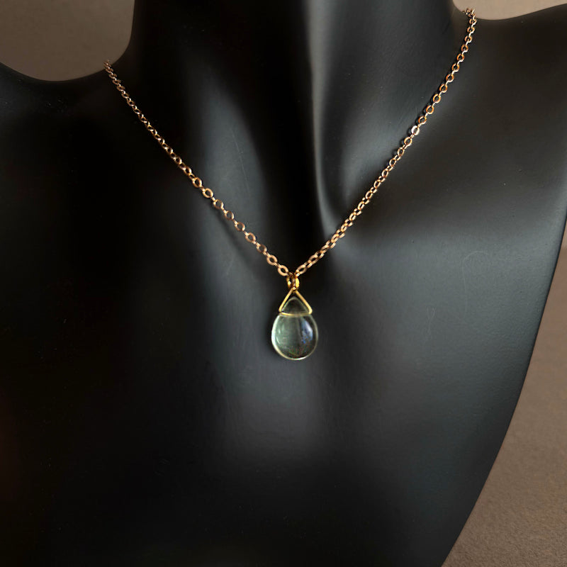 Necklace with a pendant on a mannequin against a neutral background Blue fluorite teardrop pendant necklace on gold paperclip chain worn on black sculptural bust
