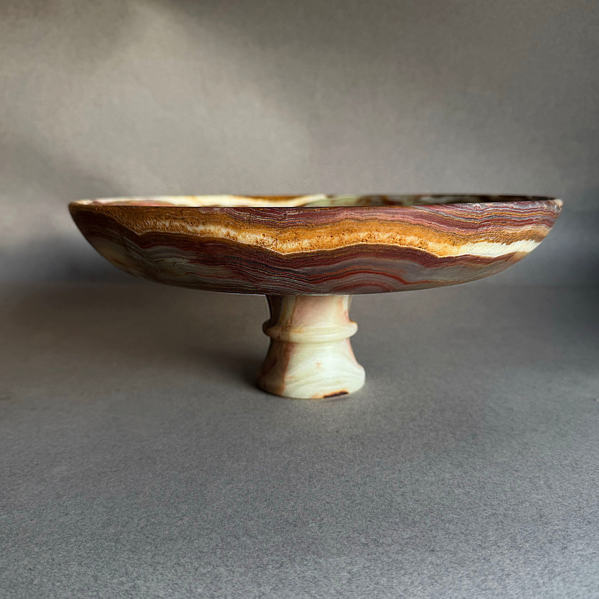 Earth-toned onyx pedestal bowl with green and plum veining, organic modern home decor centerpiece
