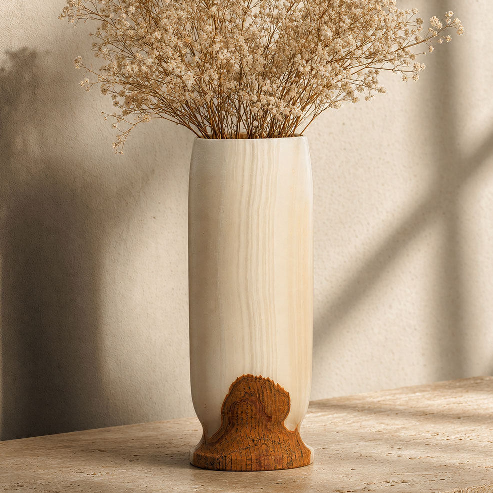 Onyx Origin Vase in pale cream with a rust and amber base, front view on a dark background.