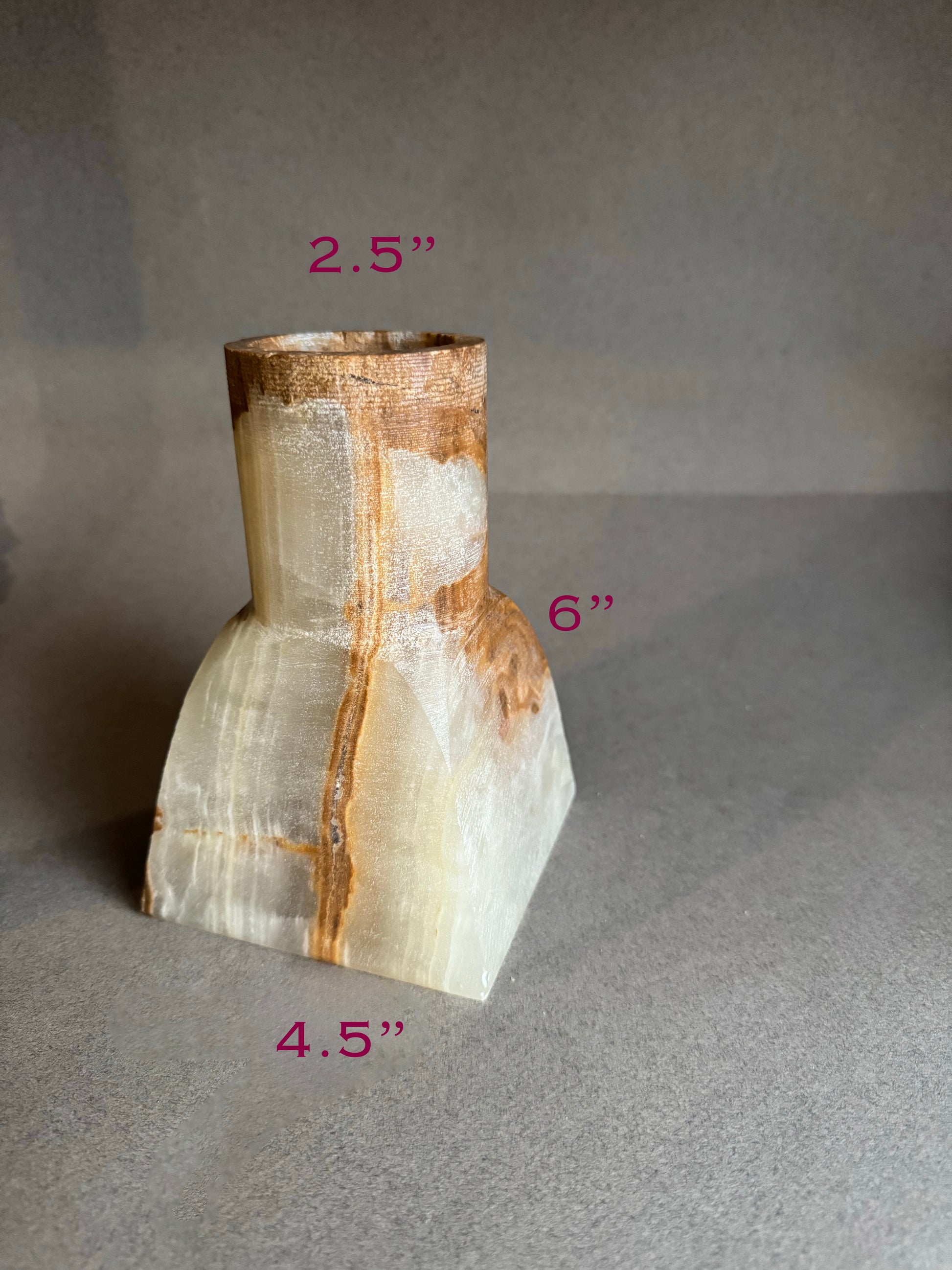 Polished onyx stone vase with measurements on a gray background