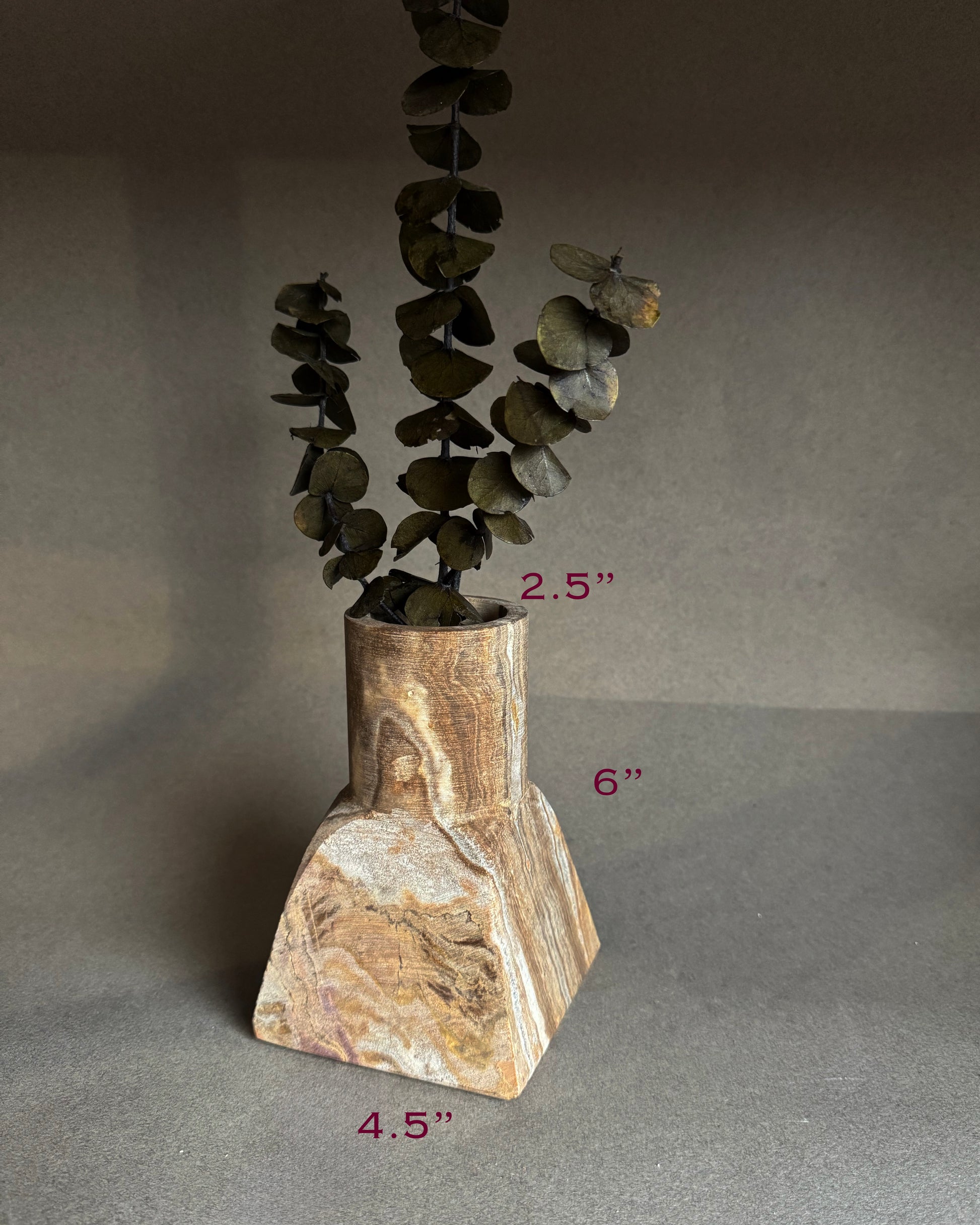 Decorative stone vase with a plant on a gray background