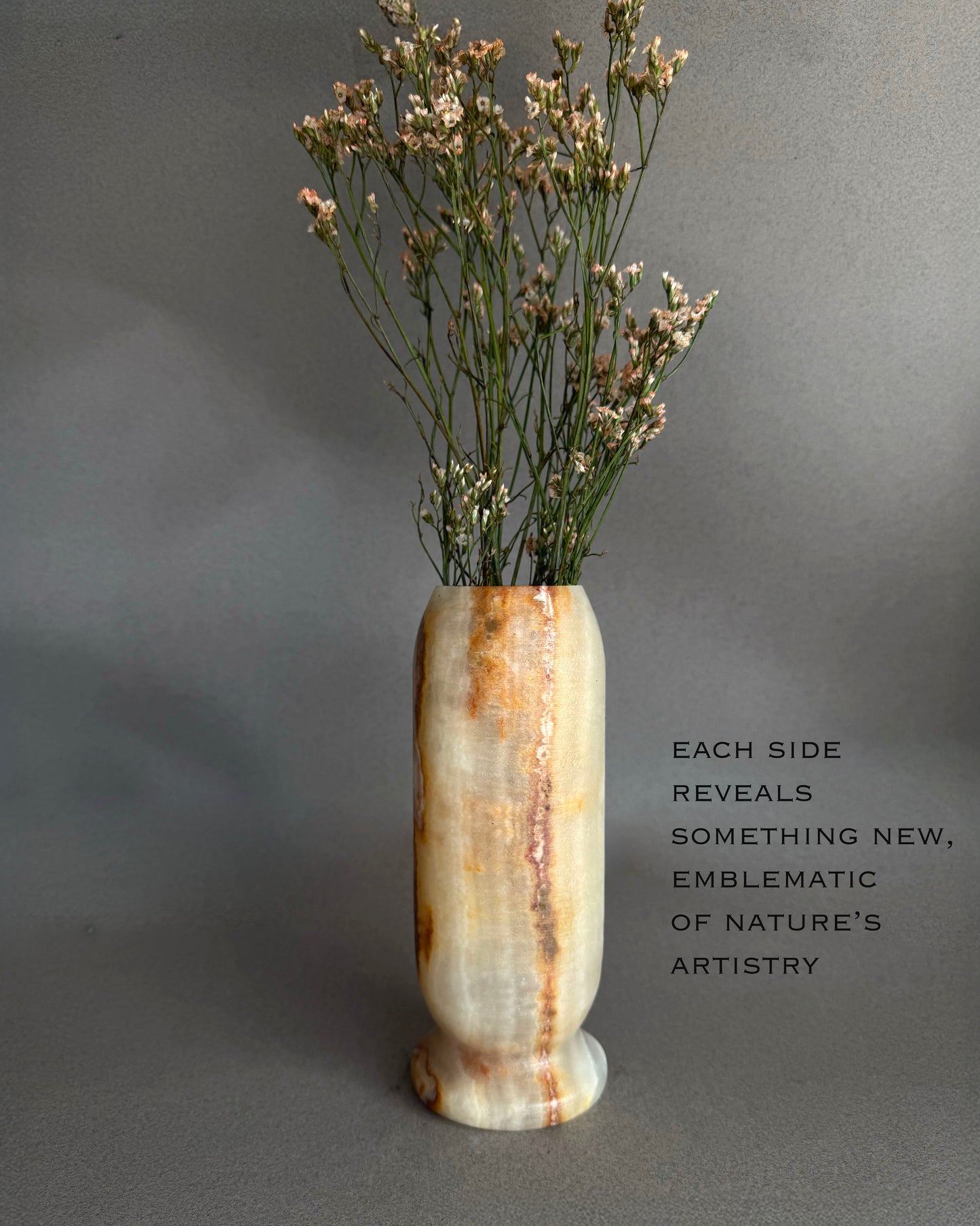 Decorative peach honey white yellow ivory onyx natural stone vase with dried flowers on a gray background