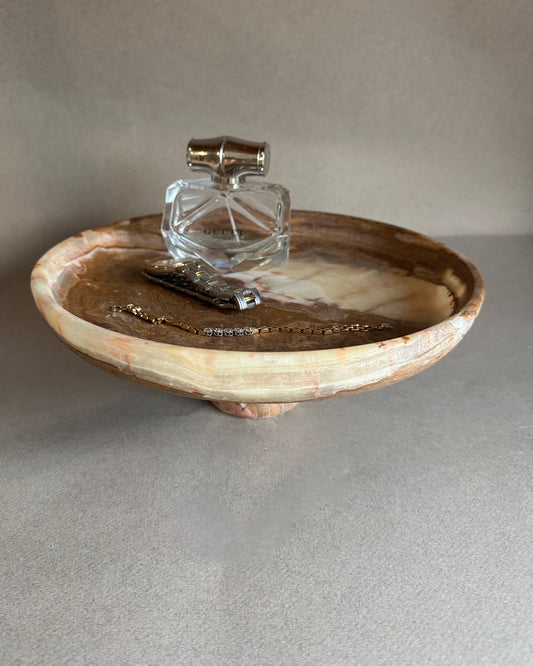 Decorative stone bowl with a clear glass container on a neutral background