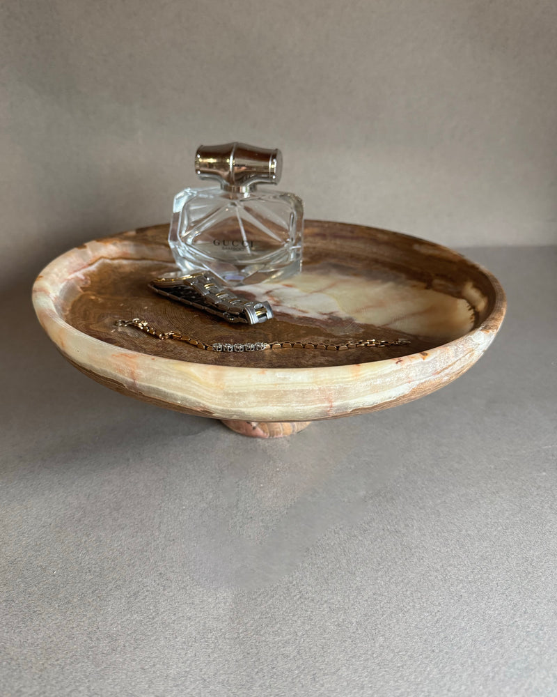 Decorative stone bowl with a clear glass container on a neutral background