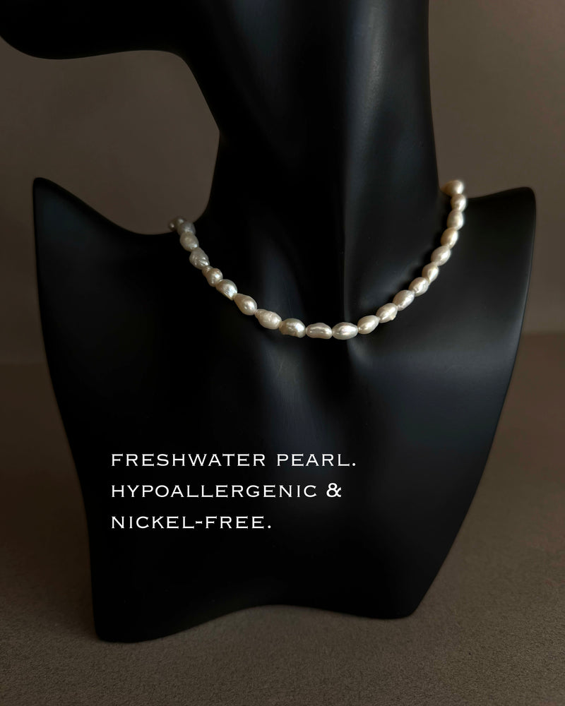 Pearl necklace on a black mannequin bust with text indicating freshness, hypoallergenicity, and nickel-free properties. 16 inch freshwater pearl choker necklace displayed on black sculptural bust, minimalist pearl jewelry
