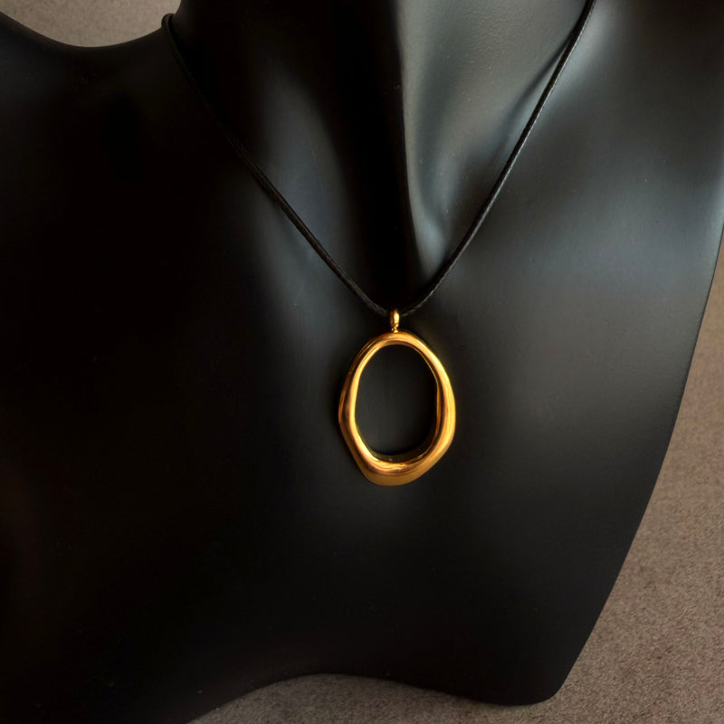 Gold filled pendant necklace on leather black cord on a black mannequin bust