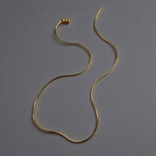Gold necklace on a gray background with text indicating gold type and length options.