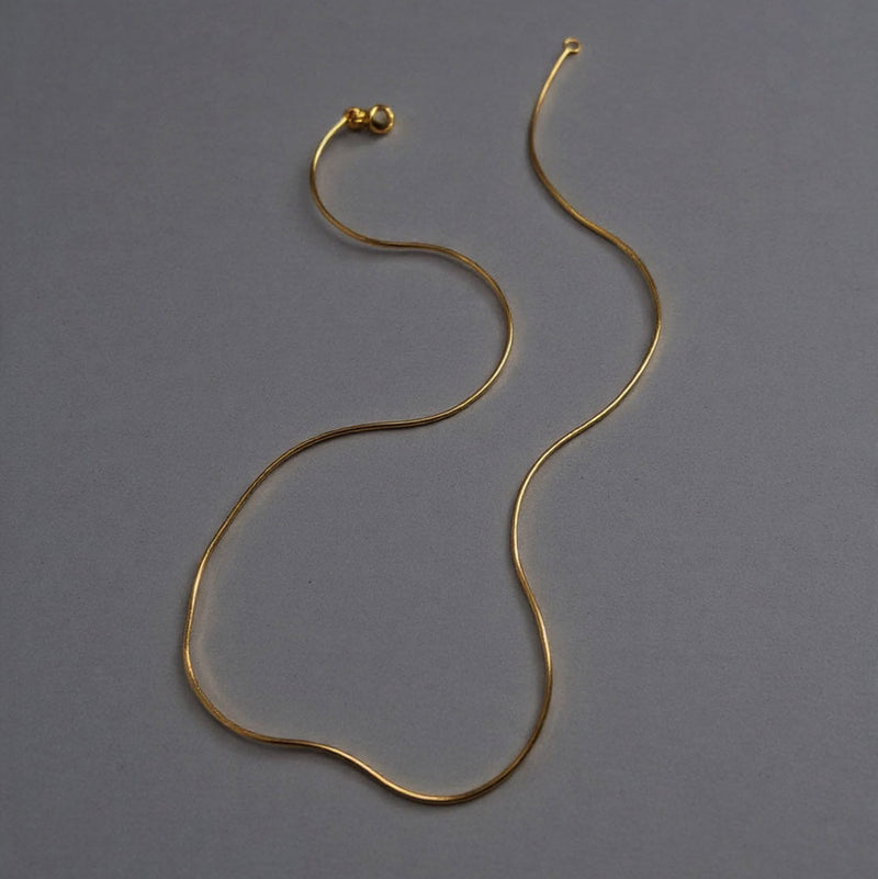 Gold necklace on a gray background with text indicating gold type and length options.