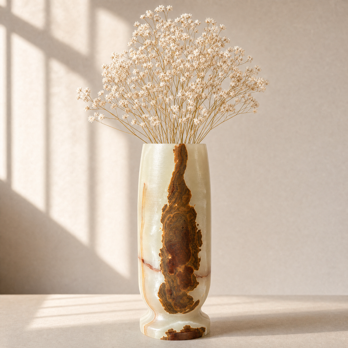 Decorative vase with dried flowers on a light surface with a neutral background