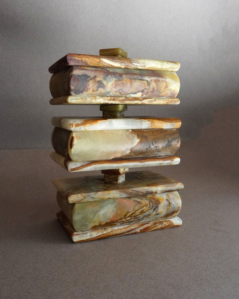 Stack of multicolored onyx keepsake trinket boxes on a gray background