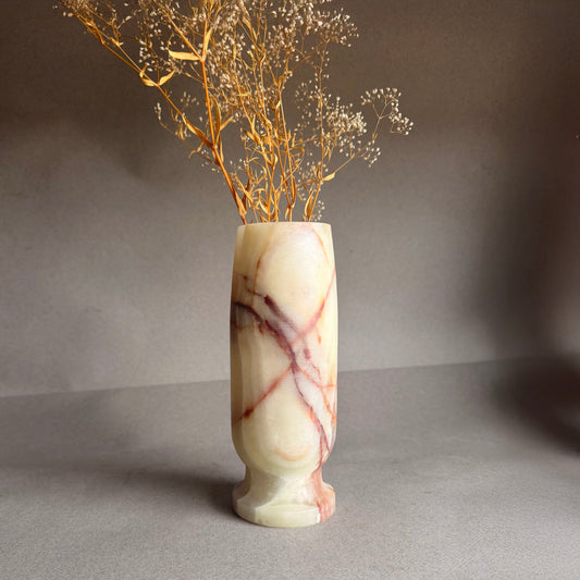 Marble-patterned vase with dried branches on a gray background