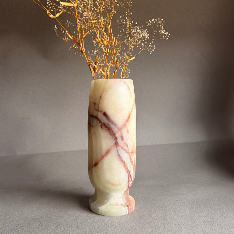 Marble-patterned vase with dried branches on a gray background