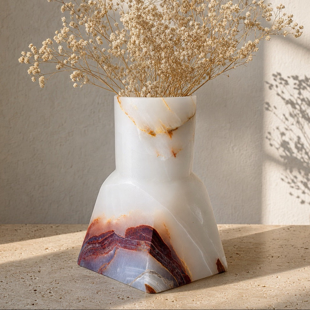 Ivory onyx Dune Vase with rust and blue-grey base veining, styled with dried baby's breath on a sunlit stone surface.