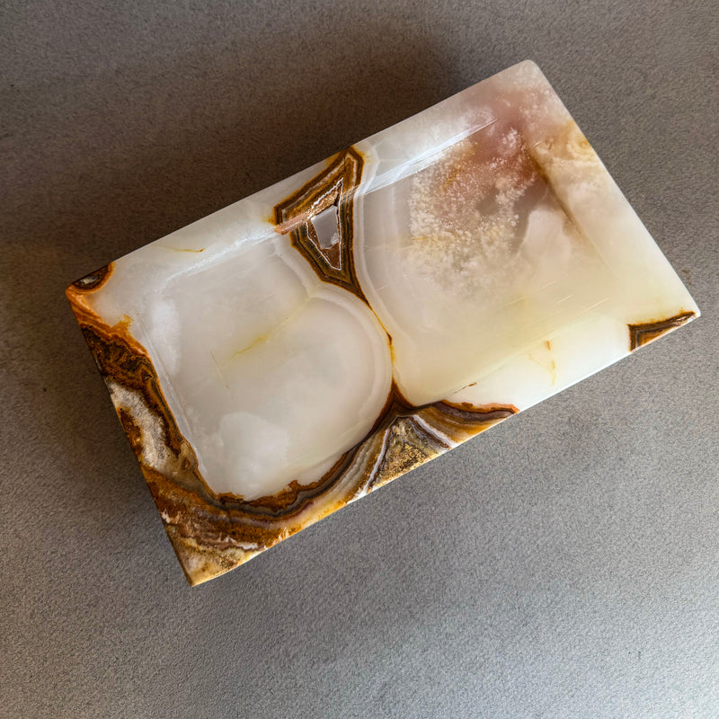 Hand-carved ivory and honey onyx catchall tray with translucent natural stone, raw polish-free onyx vanity tray styled with jewelry and perfume
