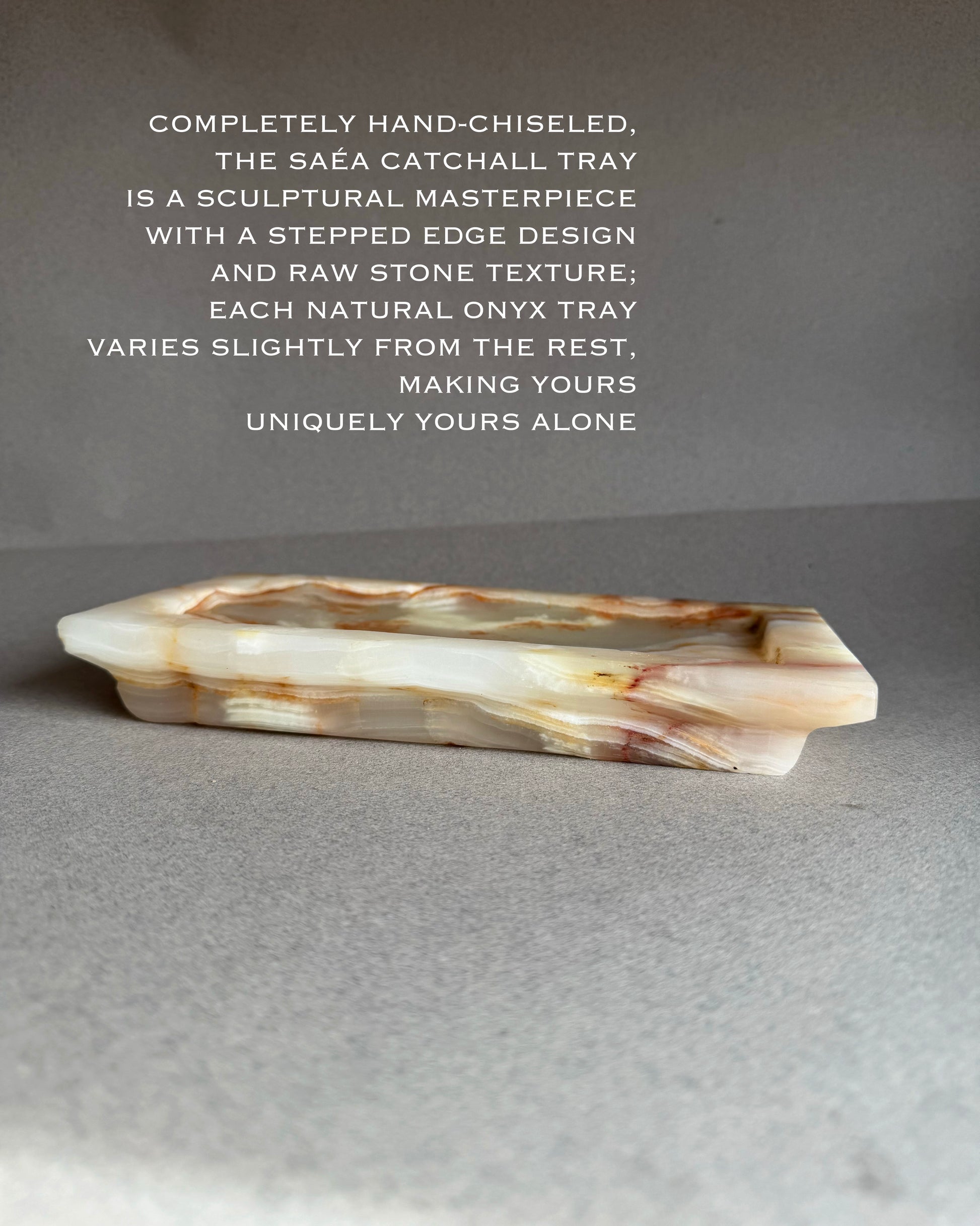 Hand-chiseled onyx catchall tray with descriptive text on a gray background