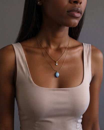 Blue kyanite gemstone necklace worn at collarbone on 18-inch gold chain, dainty minimalist style for everyday wear.
