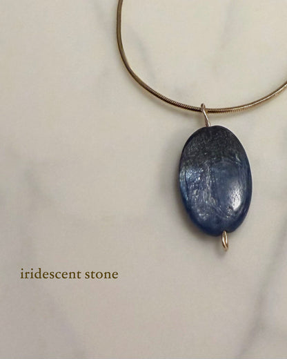 Necklace with an iridescent blue kyanite stone pendant on a light background