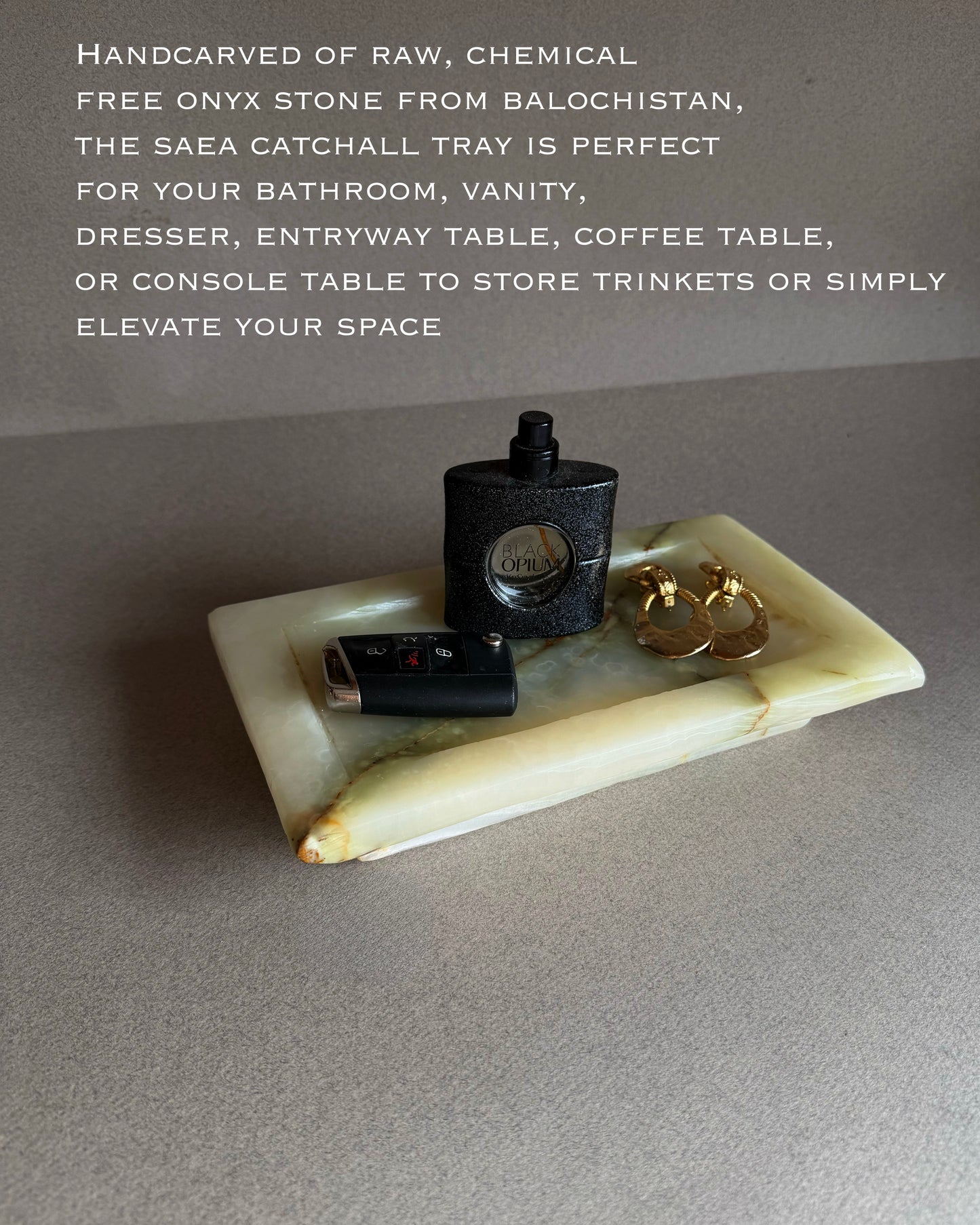 Onyx catchall tray with small items on a gray surface, text describing the product.