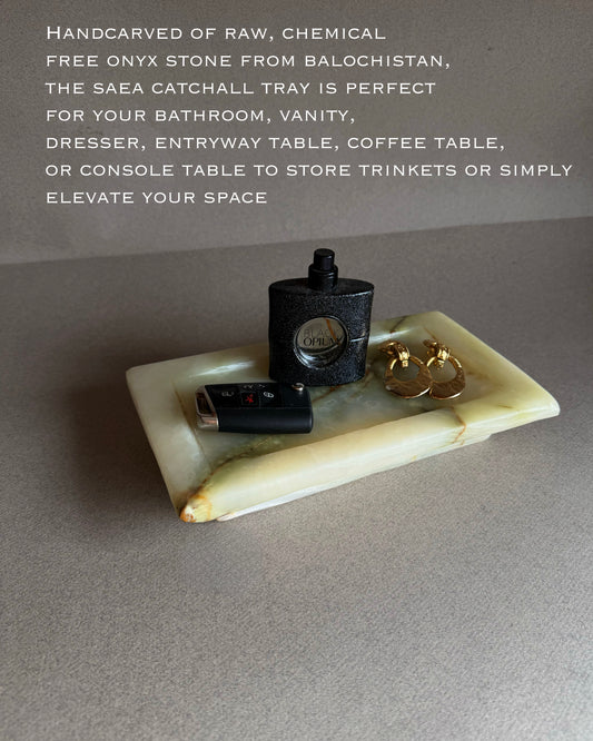 Onyx catchall tray with small items on a gray surface, text describing the product.