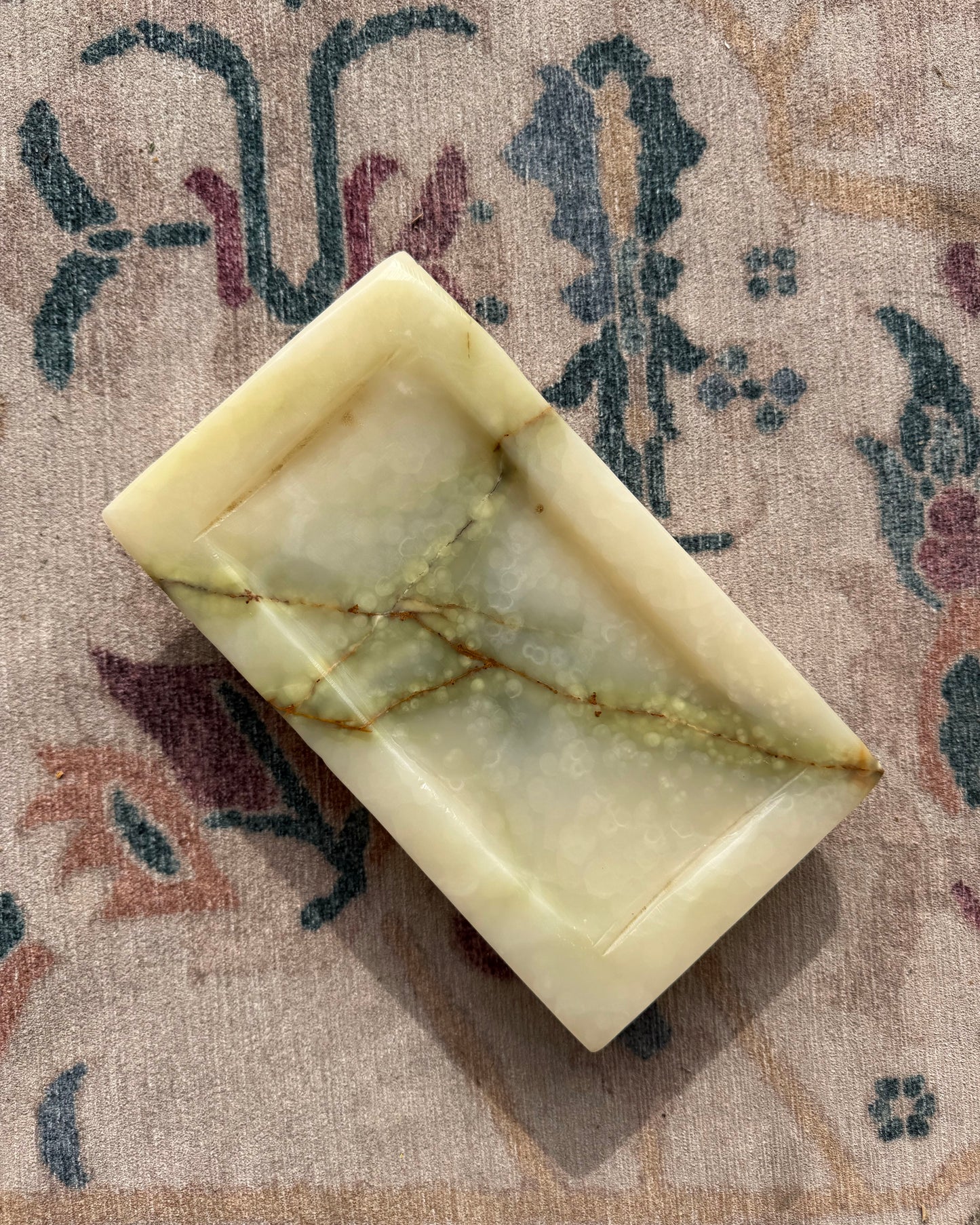 Rectangular onyx tray with a marbled pattern on a textured surface