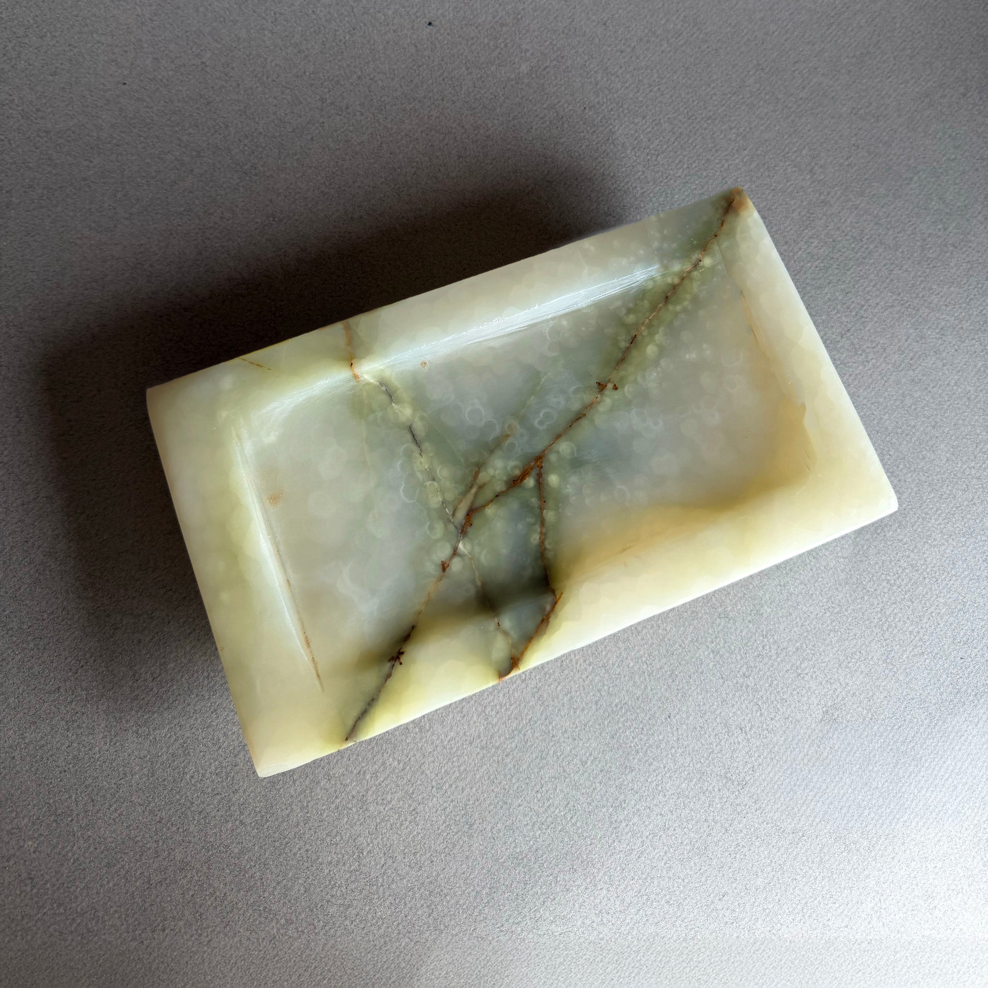 Marble-patterned onyx tray on a gray background