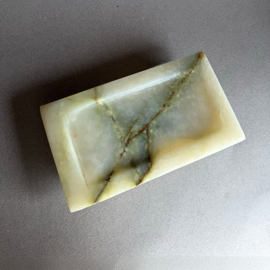 Marble-patterned onyx tray on a gray background