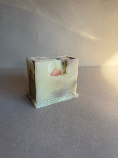 Onyx coaster set with six square stone coasters and a matching holder, ivory and amber colors with natural veining.