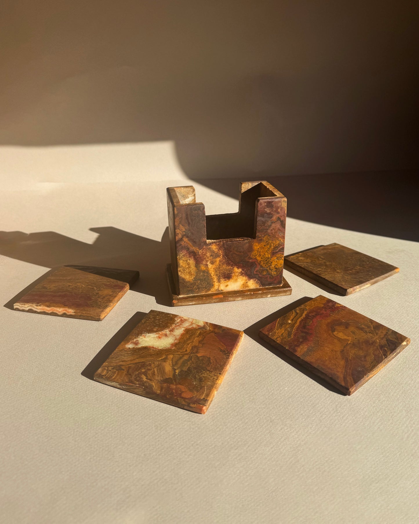 Set of rusted metal square  coasters on a neutral background