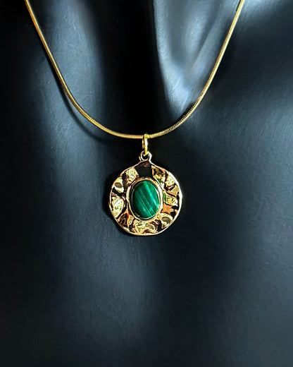 Malachite pendant necklace with gold filled snake chain photographed on soft gray fabric
