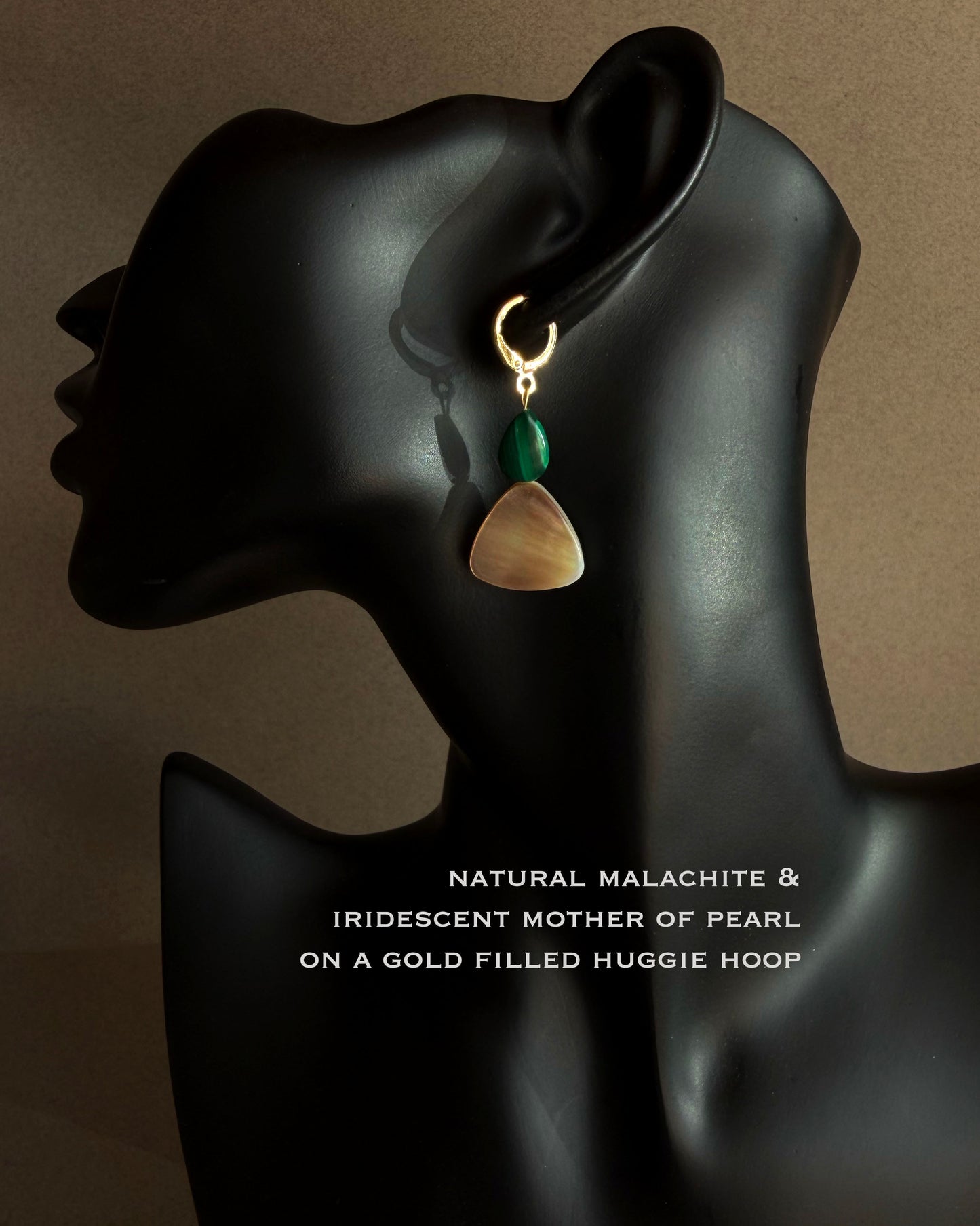 Earring on a black mannequin ear with text describing gemstones and material. MALACHITE MOTHER OF PEARL GOLD HOOP HUGGIE 