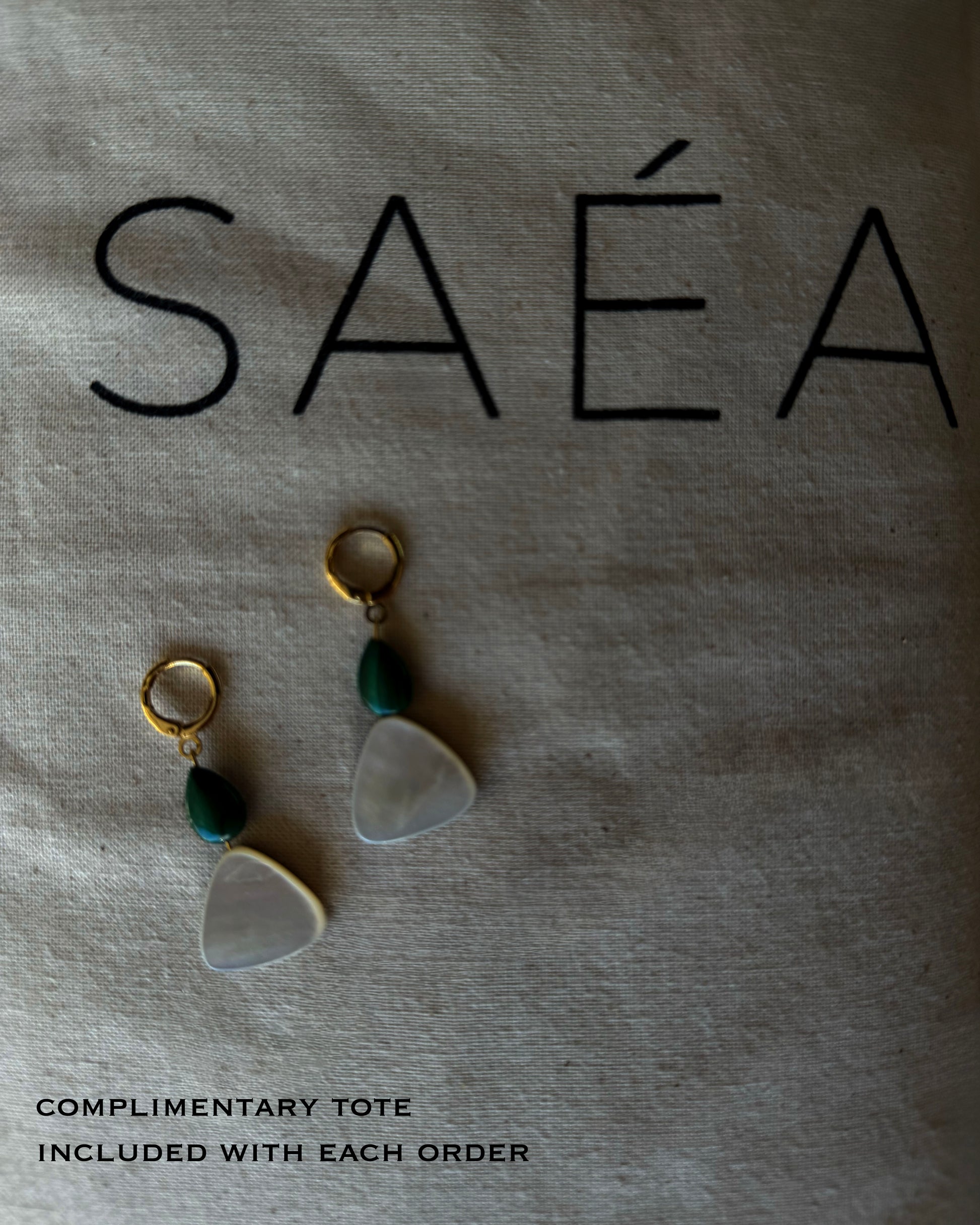 Pair of earrings with green beads on a textured surface with 'saéa' branding. MALACHITE MOTHER OF PEARL GOLD HOOP HUGGIE 